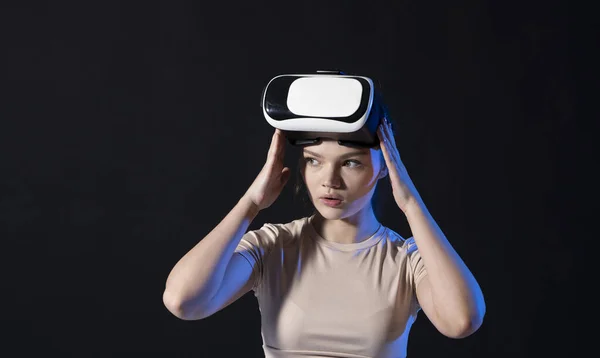 Mujer morena gamer con gafas de realidad virtual listo para jugar un juego o explorar el medio ambiente en un mundo metaverso. Tecnologías modernas. — Foto de Stock