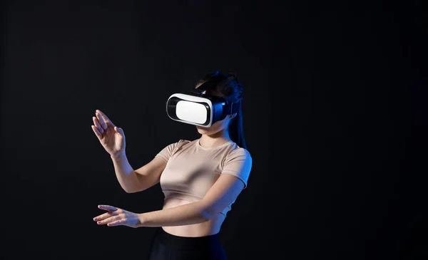 Architekt korzystający z okularów wirtualnej rzeczywistości w miejscu pracy i pracujący nad nowym projektem. Kobieta pracująca w okularach VR w neonowym świetle. Projektant pracujący w studiu VR. — Zdjęcie stockowe