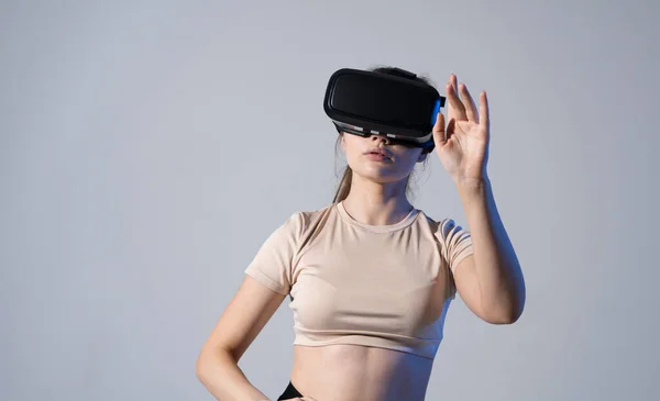 VR, kiterjesztett valóság, tudomány, jövőbeli technológiai koncepció. Fiatal barna nő szemüvegben a virtuális valóság neon fényben. Futurisztikus 3D-s szemüvegek virtuális vetítéssel. — Stock Fotó