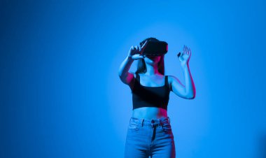 Tasarımcı, mimar, mühendis veya müteahhit kadın VR gözlük takarak stüdyoda duruyor ve zumluyor, sanal bir alanda elle zumluyor projeler üzerinde çalışırken nesnelerle etkileşime geçiyor..