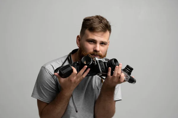 Bearded professional photographer with a bunch of different vintage film cameras in a hands looking on a camera and ready for make a good shoot. — Stock Photo, Image