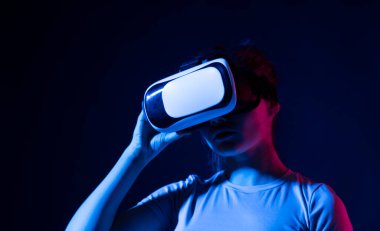 Genç kadın geliştirici, tasarımcı ya da mimar VR kulaklığı kullanarak VR teknolojisini kullanarak yeni bir ürün ya da teknoloji tasarlıyor. Gelecekteki teknoloji konsepti.