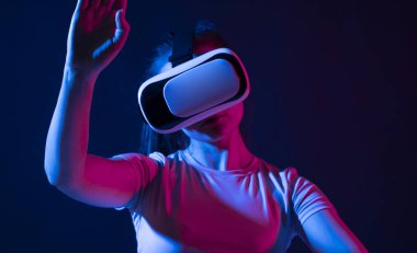 Sanal gerçeklik teknolojisi kavramı. Stüdyoda VR gözlüklü genç bir kadının portresi havada sallanıyor..