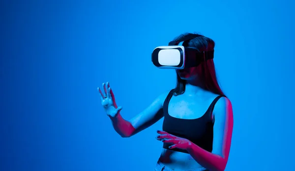 Удивительная женщина получает опыт использования очков виртуальной реальности и изучения виртуального мира. Девушка проводит время в метавселенной, тусуясь с друзьями. — стоковое фото