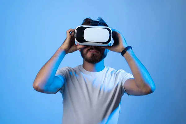 Fremtidig teknologi, spill, underholdning og medarbeiderkonsept - lykkelig ung mann med virtuell virkelighet hodetelefoner eller tredimensjonale briller som spiller dataspill i metavers. – stockfoto