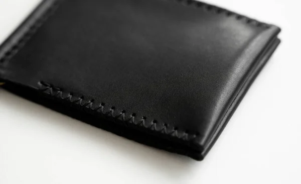 Billetera de cuero hecha a mano con clip negro para hombre. Cartera de clip de dinero vacío con dos bolsillos para tarjetas se encuentra en una mesa blanca. Enfoque selectivo, espacio de copia. — Foto de Stock