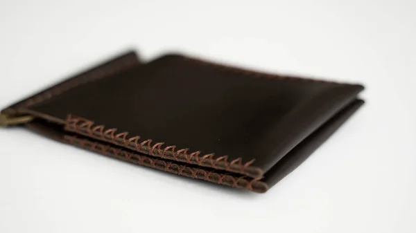 ブラウンメンズマネークリップ手作りレザー財布。カード用の2つのポケット付きの空のお金クリップ財布は白いテーブルの上にあります。選択的焦点、コピースペース. — ストック写真