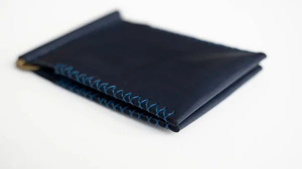 Пустые синие мужские деньги клип ручной работы кожаный бумажник с двумя карманами для карт лежит на белом столе. Селективный фокус, пространство для копирования, крупный план. — стоковое фото