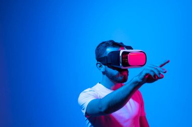 Modern mimar, iş yerinde sanal gerçeklik gözlüğü kullanan tasarımcı. Artırılmış gerçeklik vr stüdyosunda çalışan tasarımcı. Stüdyo arka planında VR gözlüklü bir adam çalışıyor.
