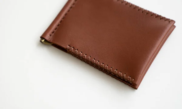 オレンジメンズマネークリップ手作りレザー財布 カード用の2つのポケット付きの空のお金クリップ財布は白いテーブルの上にあります 選択的焦点 コピースペース — ストック写真