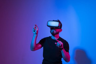 Modern mimar, iş yerinde sanal gerçeklik gözlüğü kullanan tasarımcı. Artırılmış gerçeklik vr stüdyosunda çalışan tasarımcı. Stüdyo arka planında VR gözlüklü bir adam çalışıyor.