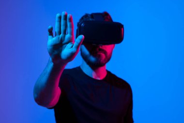 Sanal gerçeklik kasklı genç sakallı adam internette metaverse olarak oyun oynuyor. Oyun kurgusal dünyada davranışları, aletleri ve sanal gerçeklik bağımlılığını taklit eder. Gelecekteki teknoloji konsepti
