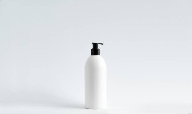 Beyaz arka planda şampuan, saç kremi ya da duş jeli olan beyaz plastik şişe. Tasarım için şablonu düzenle