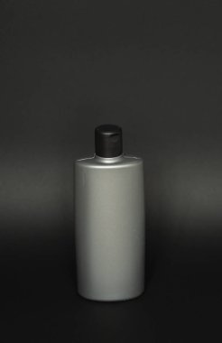 Siyah şampuan ambalaj modeli. Erkekler için dikey boş plastik kozmetik paketi, siyah arka planda izole edilmiş. Saç kremi kabı, saç durulama.