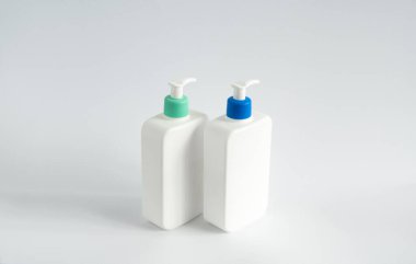 Beyaz arka planda iki beyaz markasız şeker şişesi. Kopya alanı ile kozmetik paketleme