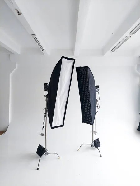 Lighting equipment on a cyclorama in modern photo studio. Two stripboxes on a c-stand on a clean white cyclorama background. Professional lighting equipment