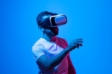 VR kulaklık takan genç adam portresi ve oyun oynarken metaevrenden bir arkadaşla konuşuyor.