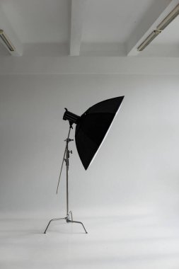 Modern fotoğraf stüdyosundaki büyük pencereli siklonamada büyük bir kutuyla profesyonel fotoğraf flaşı. Profesyonel ışıklandırma ekipmanları, flaşlar, C-standları