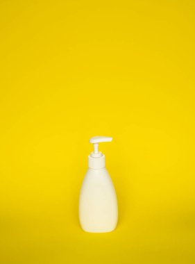 Sarı arka planda izole edilmiş beyaz plastik sabun ya da şampuan pompa şişesi. Cilt bakım losyonu. Gerekli ürünleri yıkıyorum. Şampuan şişesi. Banyo ve vücut losyonu. Güzel sıvı el yıkama.
