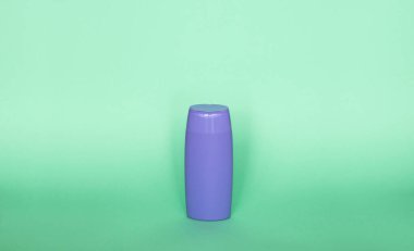Violet plastik şişe vücut bakımı ve güzellik ürünleri. Şampuan, duş jeli ve yeşil arka planda izole edilmiş krema için plastik şişe fotoğrafçılığı
