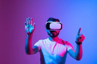 Sanal gerçeklik gözlüğü takan adam. VR teknoloji konsepti. Geliştirilmiş gerçeklik, gelecekteki teknoloji kavramı. Video kayıt cihazı. Neon ışığı