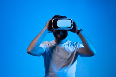 Modern mimar, iş yerinde sanal gerçeklik gözlüğü kullanan tasarımcı. Artırılmış gerçeklik vr stüdyosunda çalışan tasarımcı. Stüdyo arka planında VR gözlüklü bir adam çalışıyor.