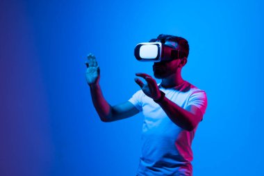 Sanal gerçeklikteki bir konuyu işaret ederken VR gözlükleriyle çalışan hırslı modern erkek.