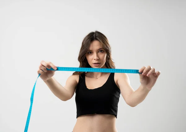 穿内衣裤的女孩在运动或健身之后手握的一厘米长的身体 身体体积的测量 健康的生活方式 体育活动 节食时的控制数字 — 图库照片