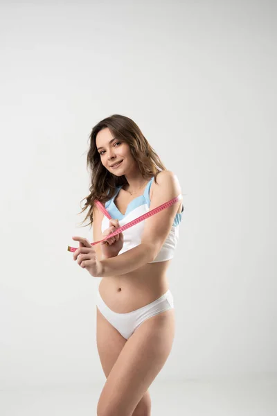 魅力的な美しさスポーツブルネットの女性はテープを保持する 白い背景に隔離されている 体積の測定 食事中の管理図 — ストック写真