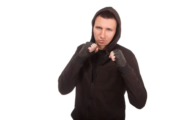 Joven con una sudadera con capucha de pie en una postura de lucha — Foto de Stock