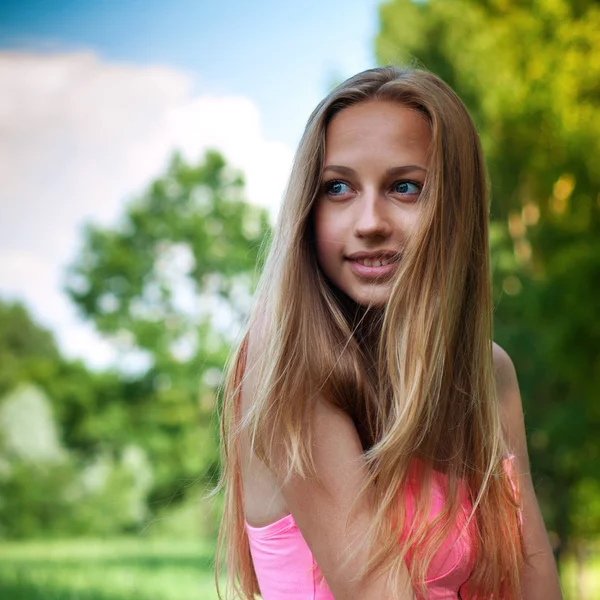 Retrato de una hermosa joven contra el cielo azul con nubes — Foto de Stock