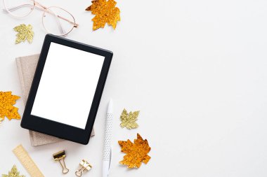 Sıcak sonbahar çalışma alanı. Ofis masası, kitap maketi, akçaağaç yaprakları ve beyaz bardaklar. Düz konum, üst görünüm, kopyalama alanı. Hygge tarzı