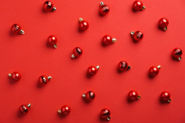 Flat lay composition with Christmas red balls on red background. Christmas pattern