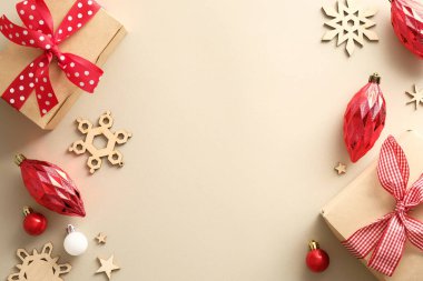 Hediye kutuları, kırmızı takılar, ahşap kar taneleri olan klasik bej rengi Noel arkaplanı. Noel tebrik kartı maketi. Yeni yıl kartpostal tasarımı.
