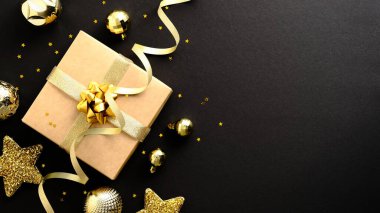 Noel afişi tasarımı. Altın madalyalar, balolar, parti flaması ve siyah arka planda konfeti olan bir Noel hediyesi. Uzayı kopyala Düz yatıyordu.