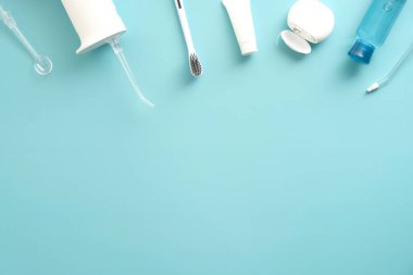 Profesyonel diş temizleyicisi, diş macunu, diş fırçası, sıvı, mavi arka planda diş ipi. Düz yerde, üst tarafta. Genel giderler. Diş sağlığı kliniği pankartı tasarımı.
