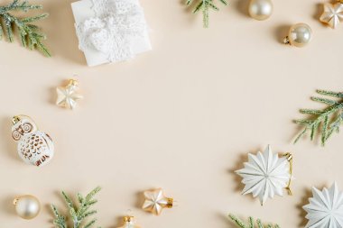 Noel kartı tasarımı. Düz kaliteli süslemeler, hediye, pastel bej arka planda köknar dalları. İskandinav, İskandinav, Hygge tarzı.