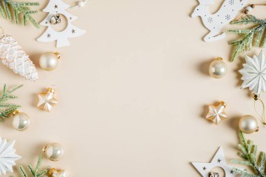 Noel aralığı. Köknar dalları, boho tarzı beyaz yıldızlar, takılar, bej arka planda çam kozalağı süslemeleri olan zarif bir Noel kartı. Düz konum, üst görünüm, kopyalama alanı