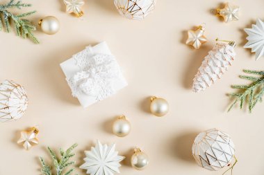 Noel bej arka planı, hediye kutusu, yıldızlar takılar, köknar dalları. Düz yatış, üst görünüm.