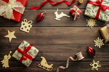 Noel hediyeleri, kırmızı kurdele, ahşap dekorasyonlu klasik Noel ağacı arka planı. Geçmiş Noel kompozisyonu. Düz konum, üst görünüm, kopyalama alanı.