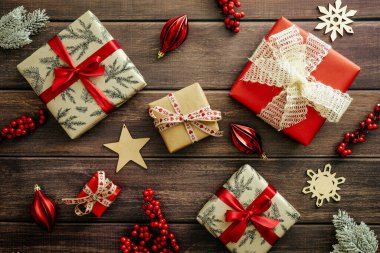 Klasik Noel kompozisyonu. Noel hediyeleri ve ahşap masadaki kırmızı mücevherler. Düz yatış, üst görünüm.