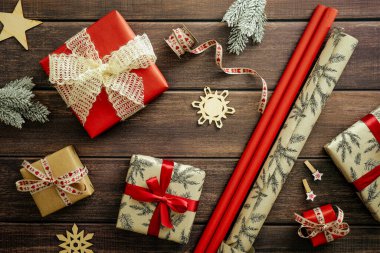 Noel kompozisyonu. Kırmızı ve el işi hediye kutuları, ambalaj kağıtları, tahta masa üzerinde köknar dalları. Dümdüz yatıyordu..