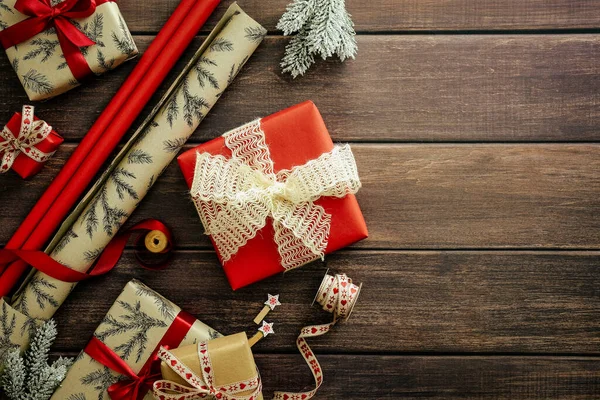 素朴な木製のテーブルの上にクリスマスのギフトボックスや包装紙 フラットレイアウト トップビュー オーバーヘッド — ストック写真