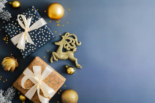 Stilvoller Weihnachtshintergrund Mit Geschenkschachteln Goldkugeln Und Rentieren Auf Dunkelblauem Tisch — Stockfoto
