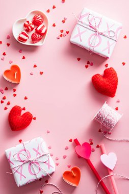 Sevgililer Günü kompozisyonun kutlu olsun. Hediye kutuları, kalpler, mumlar, pembe dikey arka planda konfeti. Aşk, aşk konsepti.