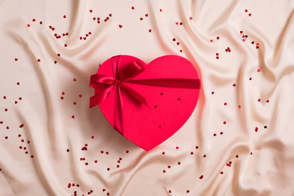 Κόκκινο Κουτί Δώρου Σχήμα Καρδιάς Τυλιγμένη Κορδέλα Παστέλ Μπεζ Ύφασμα — Φωτογραφία Αρχείου