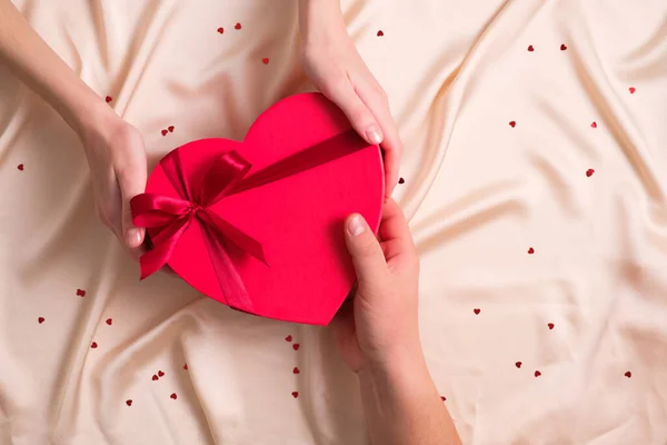 人は恋人にチョコレートのハート型の箱を与える フラットレイアウト トップビュー ハッピーバレンタインデーのコンセプト — ストック写真