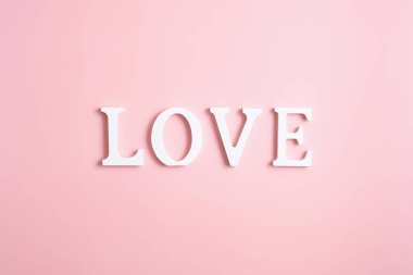 Aşk kelimesi pembe arka plandaki beyaz harflerden oluşur. Asgari düzeyde. Sevgililer günün kutlu olsun, anneler günün kutlu olsun, doğum günün kutlu olsun..