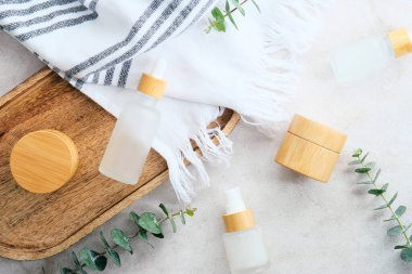 Bambudaki doğal kozmetikler ve taş masadaki cam kaplar. SPA organik güzellik ürünleri seti. Cilt bakımı kavramı.