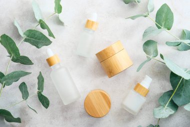 Eko kozmetik seti ve taş masada yeşil okaliptüs yaprakları. Doğal organik SPA güzellik ürünleri paketleme, markalaşma